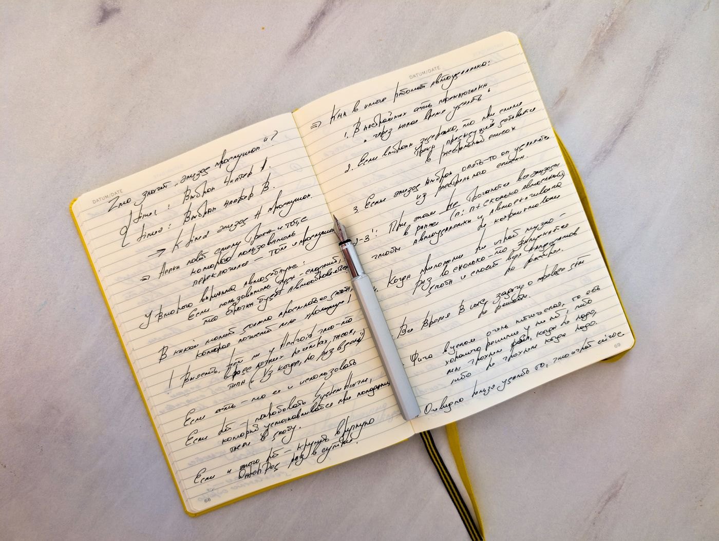 An open notebook filled with handwritten notes and a pen on its pages.