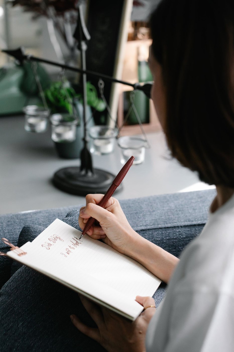 A hand writes notes in a notebook.