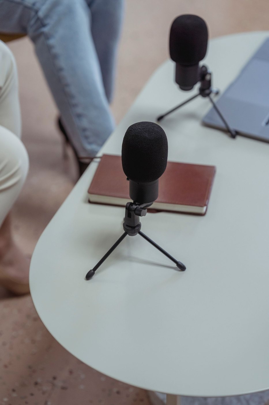 Microphones and a notebook on a table prepared for a recorded conversation.