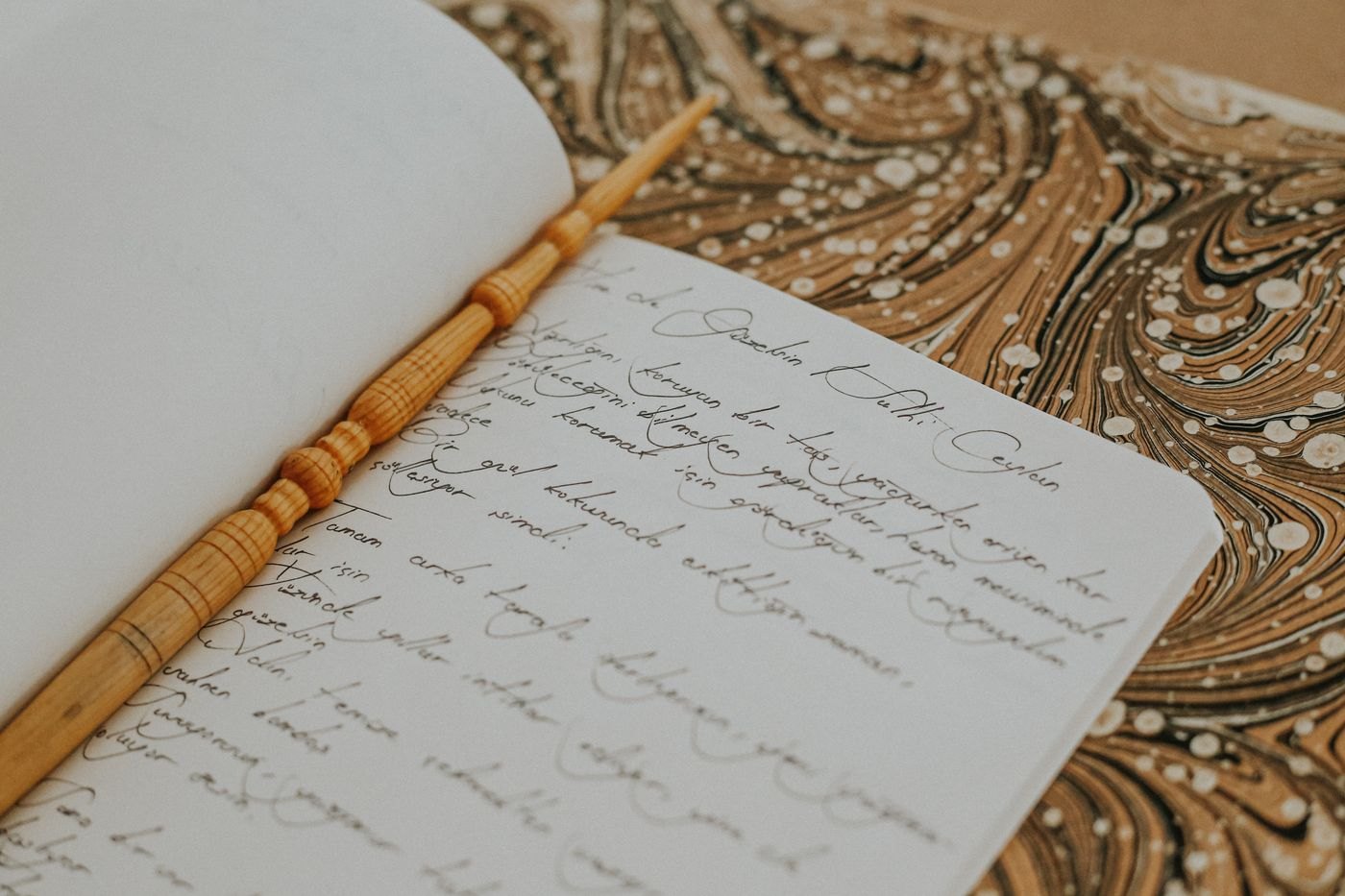 Handwritten reflections and a wooden pen in an open journal.
