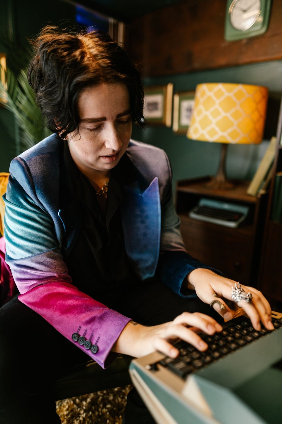 A writer sits at a typewriter working on a page.