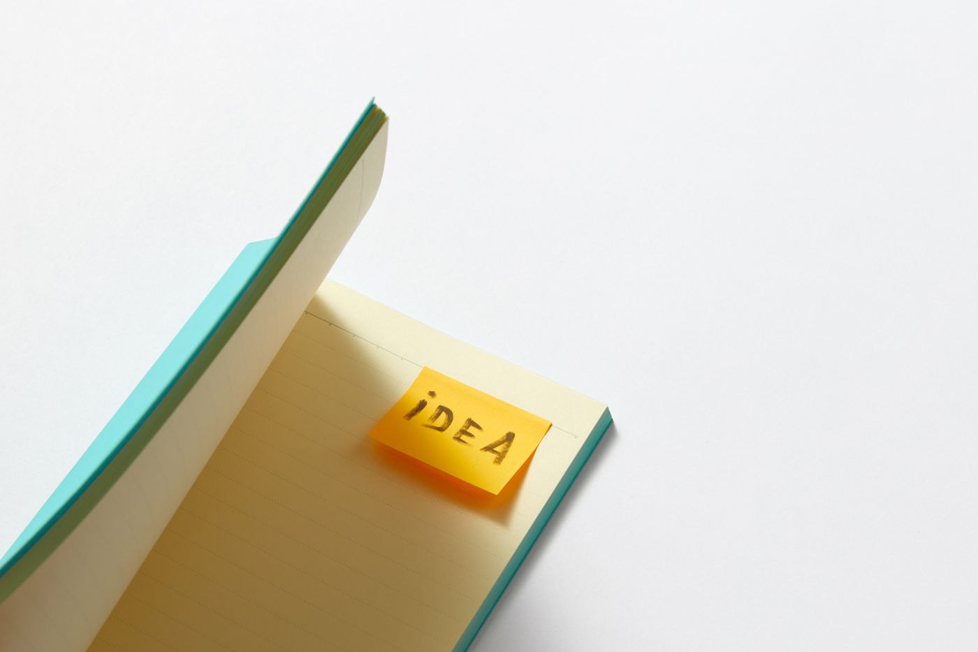 An idea note rests on an open notebook.