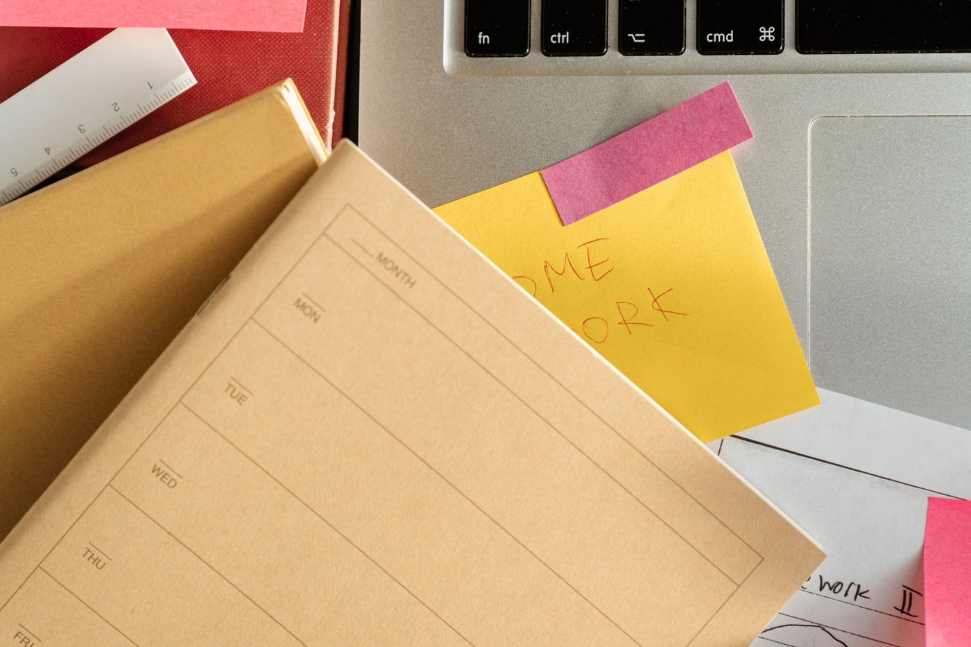 A notebook, laptop and sticky notes arranged for a review.