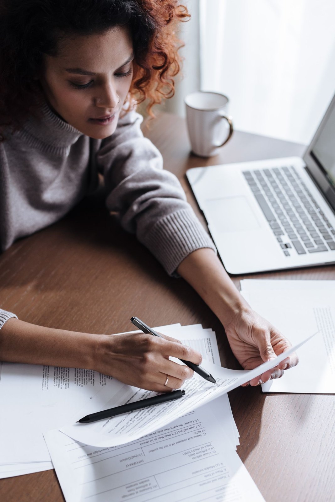 Paper document being checked beside a laptop