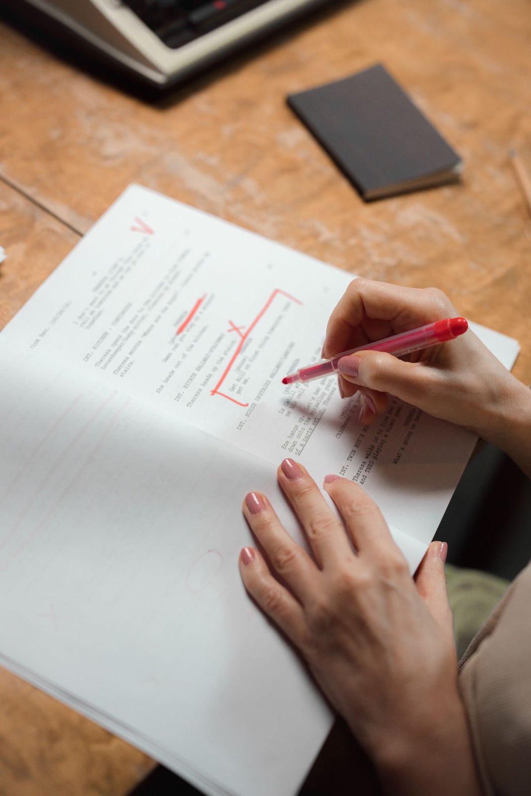 Close view of a red pen marking printed pages