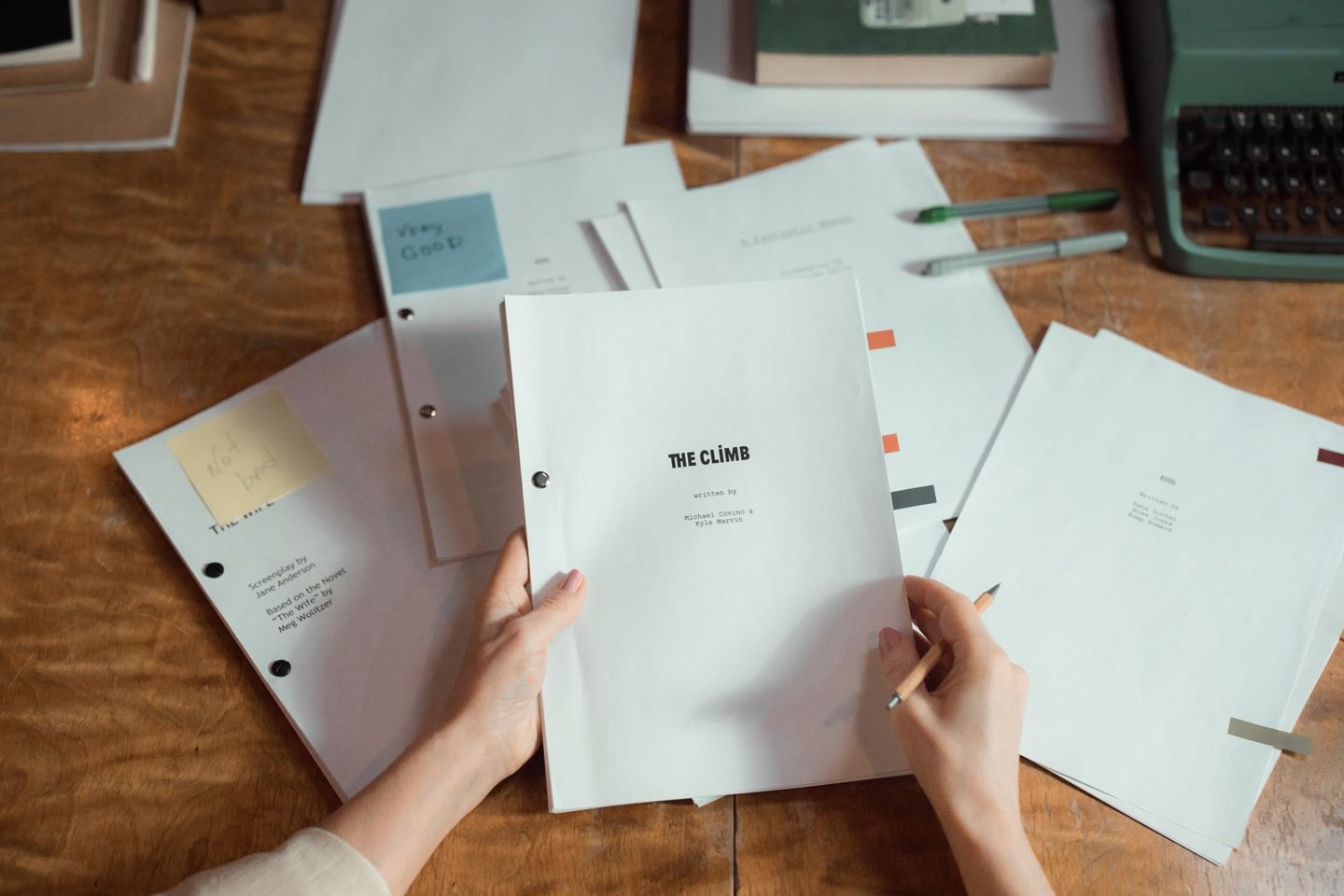 Hands sorting printed script pages on a desk