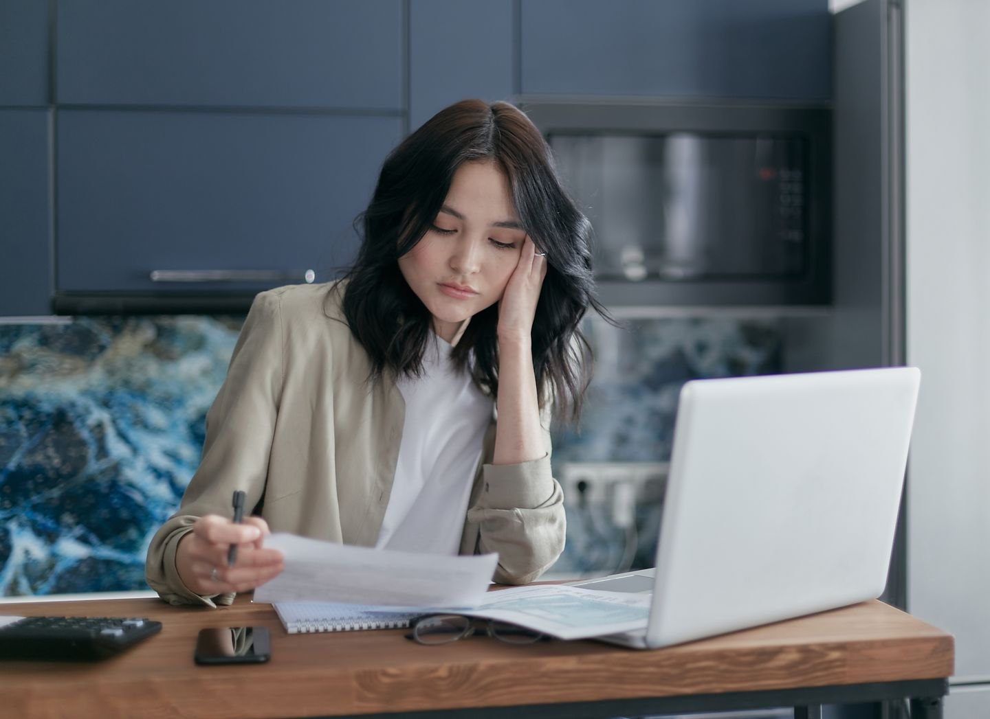 Reader checking a printed manuscript at a laptop