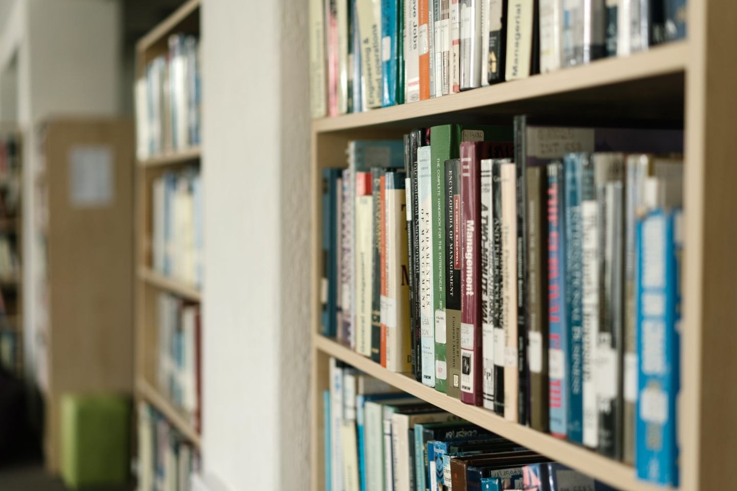 Books arranged on library shelves with catalogue labels