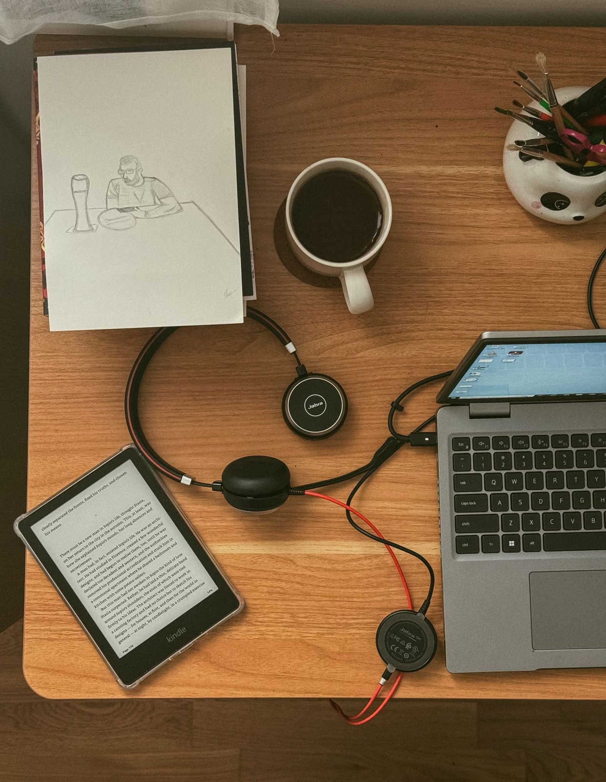 Ereader, laptop and notebook arranged on a desk