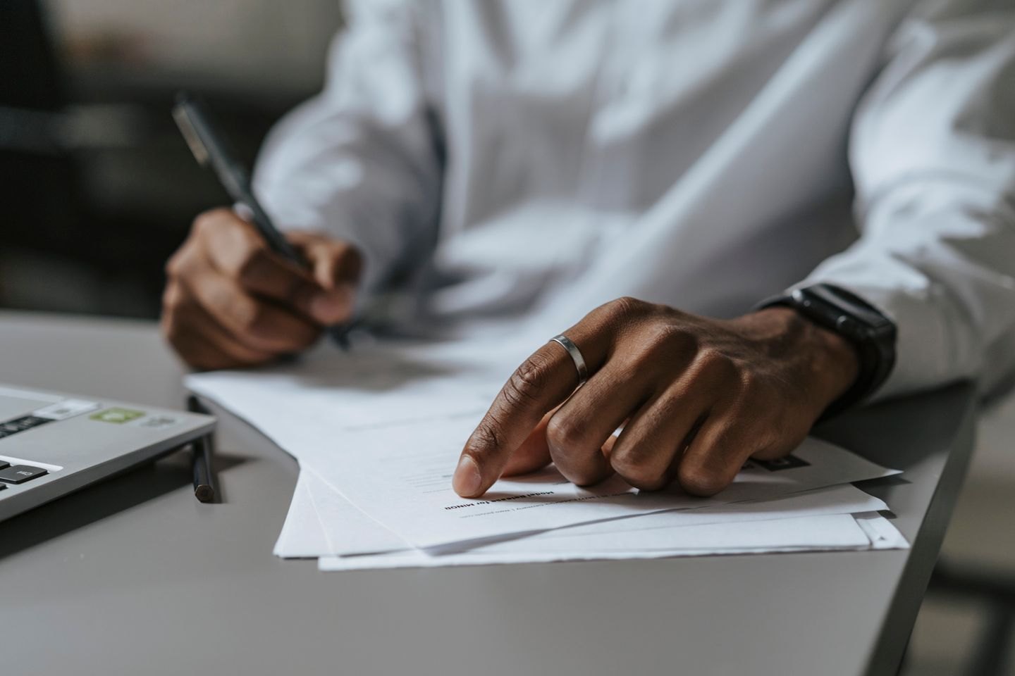 Hands reviewing a printed agreement with a pen