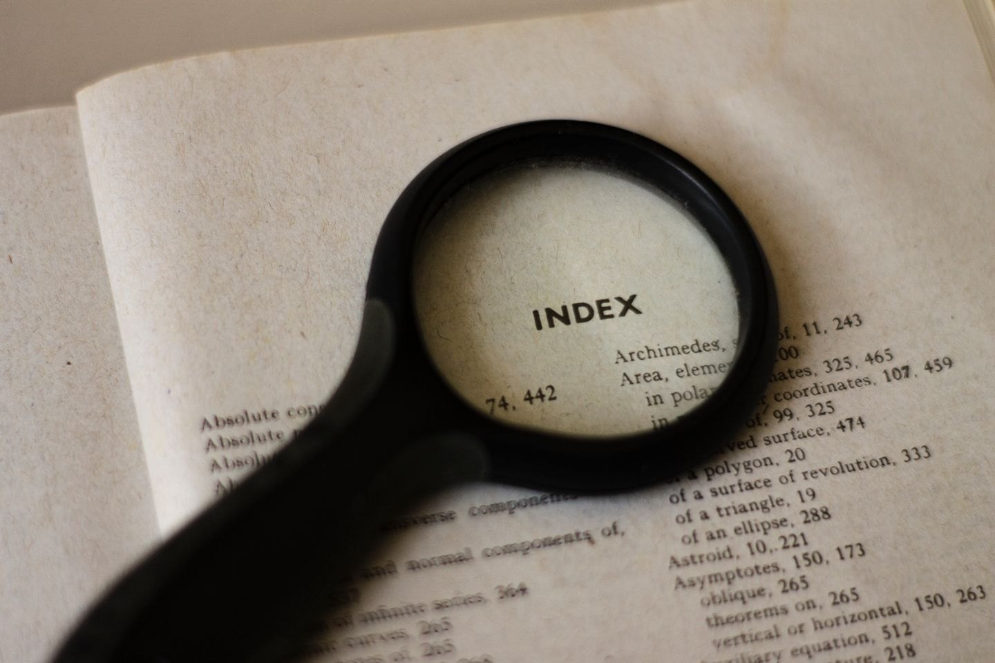 Magnifying glass above a book index