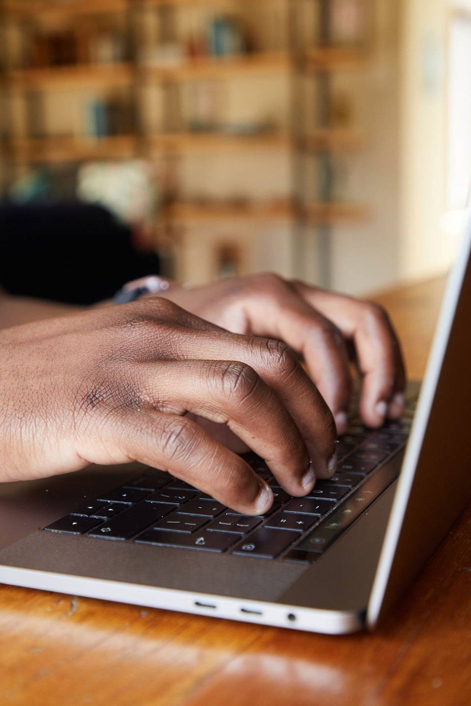 Hands typing on a laptop keyboard.