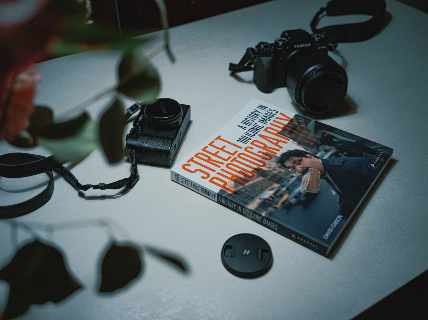Cameras and a photography book arranged on a tabletop.