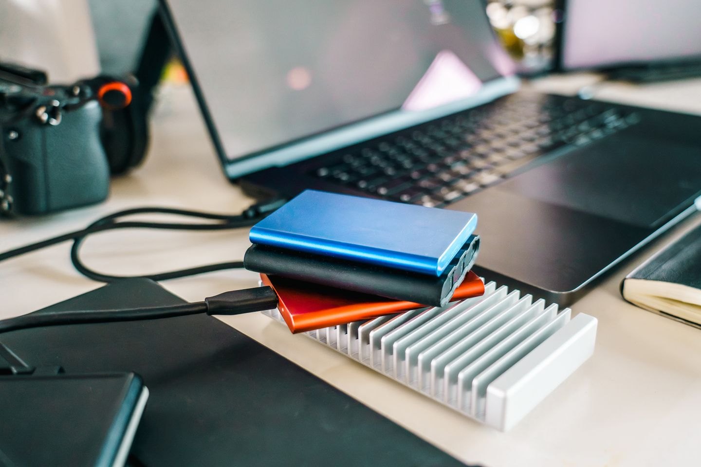 Several external storage drives connected beside a laptop.
