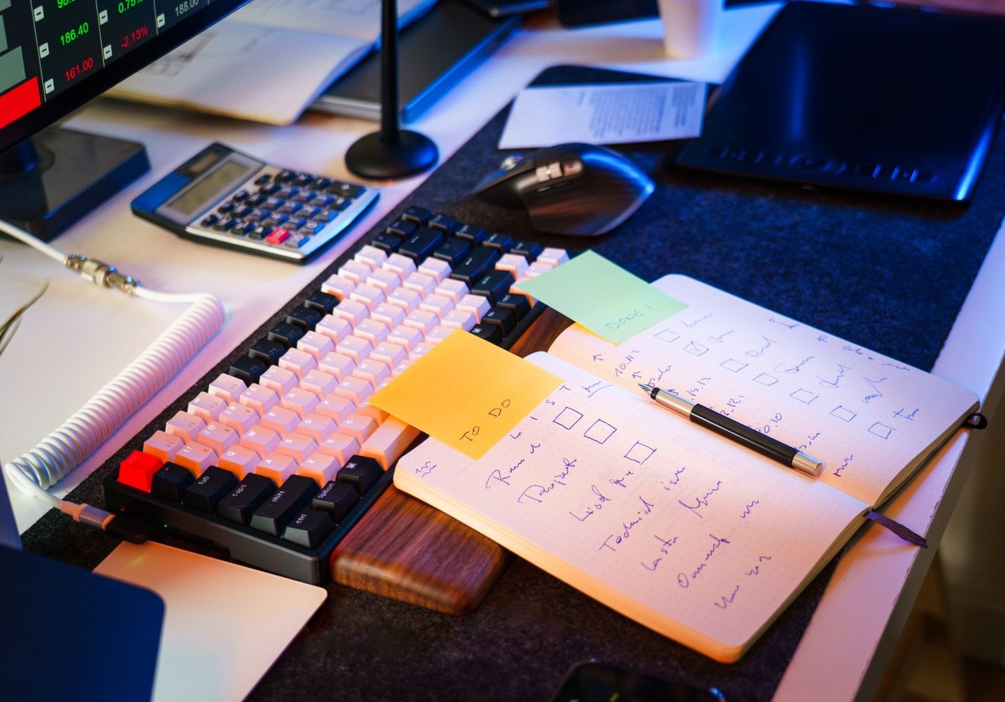 A keyboard beside handwritten notes and a checklist.